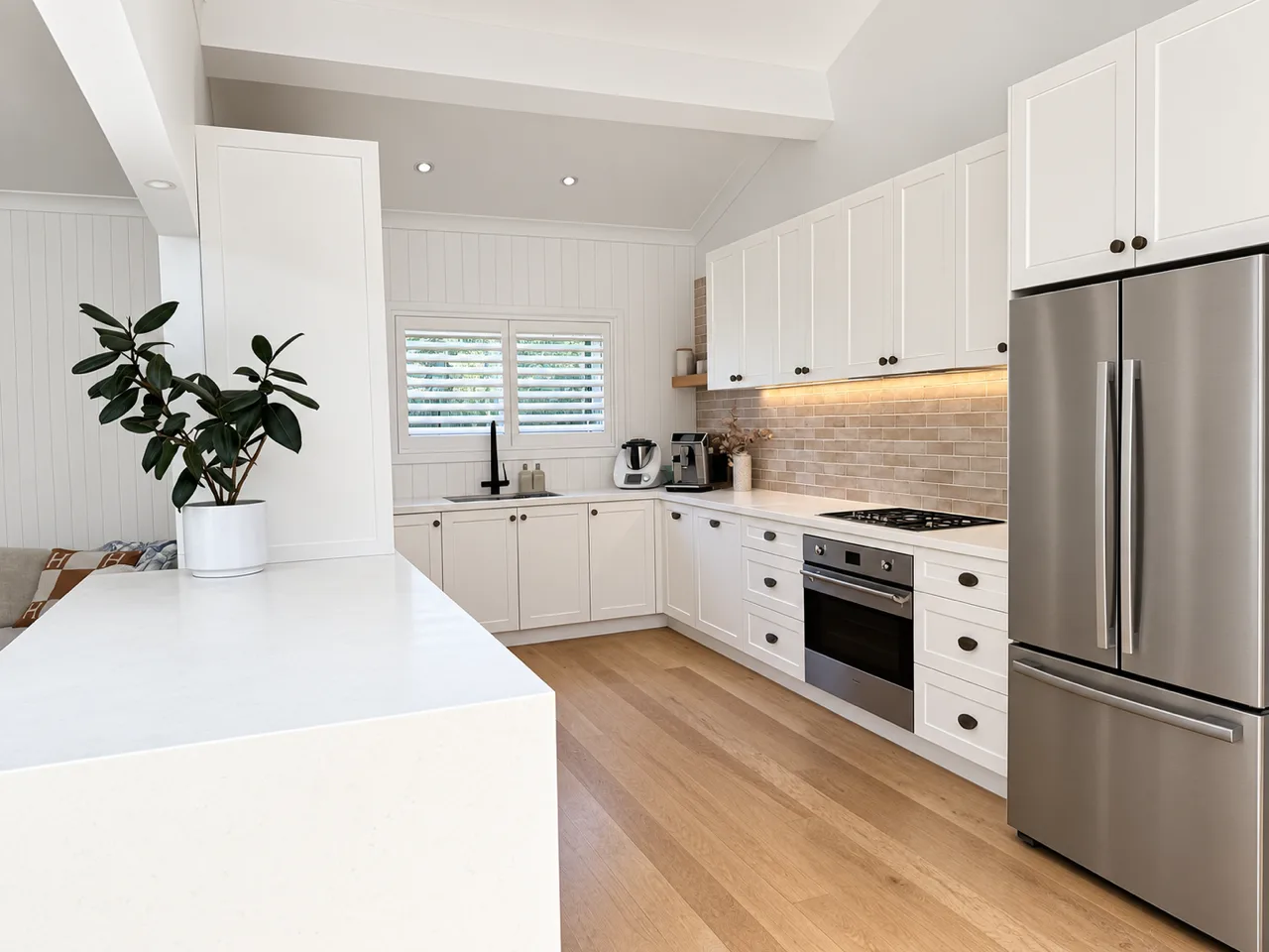 Avalon kitchen after: shaker cabinets, brick splashback, timber floor and stone benchtop